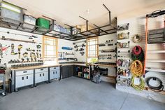 a garage filled with lots of different tools and equipment on the walls, including shelves