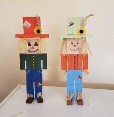 two paper dolls made to look like they are wearing scarecrows and hats, standing next to each other