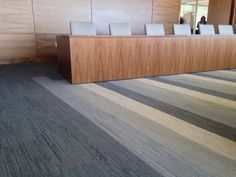 an empty room with chairs and desks in the center, along with wood paneling