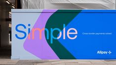 a large sign on the side of a building that says simple with an abstract design