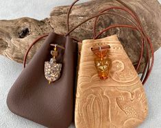 two purses sitting next to each other on top of a white surface with wood