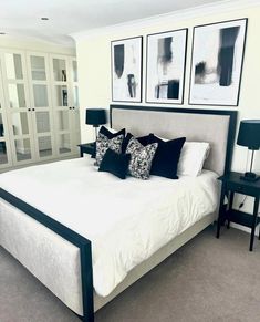 a bedroom with white bedding and black pillows