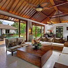 a living room filled with lots of furniture next to a large open area covered in wood