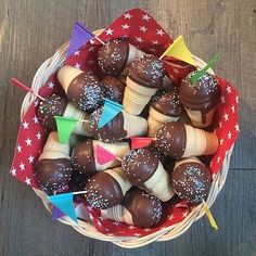 a basket filled with chocolate covered strawberries and colorful flags on top of each other