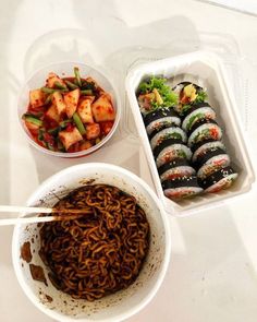 two bowls with chopsticks and some food in them