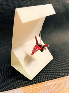 an ornament in a white box with a red bird on it's back