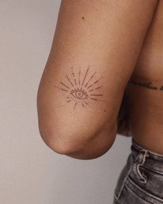 a person with a small tattoo on their arm and shoulder, showing the sun behind them