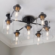 a light fixture with five clear glass shades on the ceiling and four lights attached to it