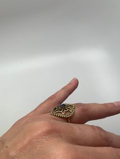 "This ring makes a gorgeous statement. The polished black onyx stone is set in brass floral tribal design details. The back is open to allow direct contact with the stone. Ring is approx 7/8\" length on face US size 7.75"