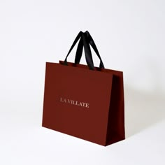 a red shopping bag with the name eavillie on it, against a white background