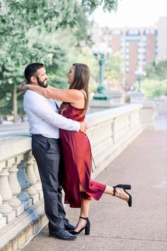 a man and woman standing next to each other on a bridge