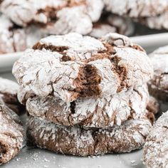 chocolate crinkle cookies piled on top of each other with powdered sugar in the middle