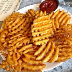 a white plate topped with french fries and ketchup