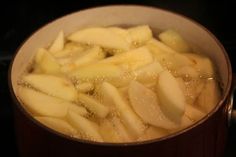 sliced apples are being cooked in a pot on the stove with water and oil around them