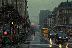 cars driving down a street in the rain