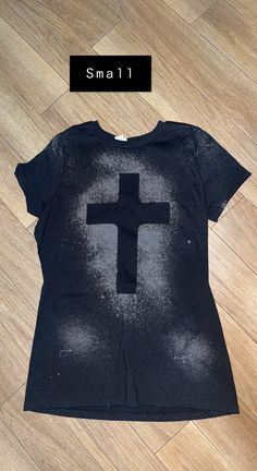 a black t - shirt with a cross on it