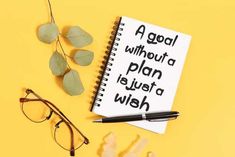 a notebook with the words goal without a plan on it next to eyeglasses