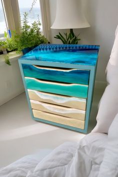 a blue and white dresser sitting on top of a bed