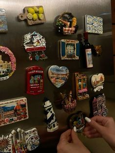 the refrigerator is covered in magnets and other decorative items that are hanging on the wall