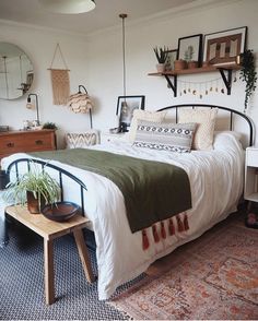 a bed room with a neatly made bed and lots of decorations on the wall above it