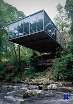 a house that is sitting on top of a hill in the middle of some trees