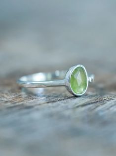 The rose cut peridot (August birthstone) shines alongside a tiny round green sapphire (September birthstone), both held securely in a bezel setting. Pair your peridot ring with peridot earrings to channel a free spirited and joyful vibe. Let this ring be the statement piece that adds a touch of whimsy and elegance to your style. Each piece of our jewelry is handcrafted with love. Green Peridot Birthstone Ring, Dainty Style, Peridot Gemstone Stackable Rings For May Birthstone, Stackable Peridot Gemstone Rings For May Birthstone, Green Sapphire Sterling Silver Ring For May Birthstone, Green Sapphire Ring For May Birthstone In Sterling Silver, Green Sapphire Ring Sterling Silver, May Birthstone, Lime Green Peridot Ring For May Birthstone, Lime Green Peridot Birthstone Ring For May, Lime Green Sterling Silver Birthstone Rings