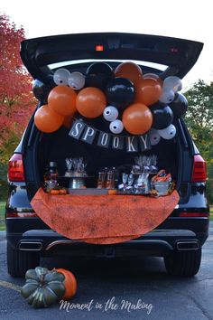 the trunk of a car decorated with balloons and pumpkins for spooky halloween party