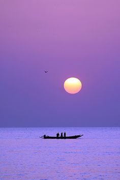 two people in a small boat at sunset