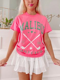 a woman with blonde hair wearing a pink t - shirt and white tennis skirt is posing for the camera