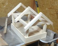 a wooden house being built on top of a workbench