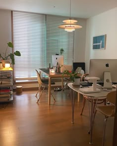 an office with desks, chairs and computers on the floor in front of windows