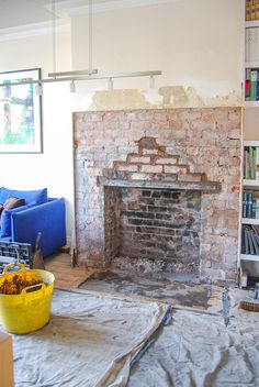 a living room with a fire place and bookshelves in the background, under construction