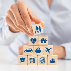 a person stacking wooden blocks with icons on them