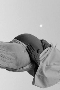 a black and white photo of a pregnant woman with her hands on her belly as if she were in the air