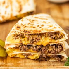 two quesadillas stacked on top of each other with cheese and meat in the middle