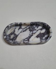 a marbled tray with white and black designs on the edges is sitting on a table