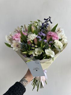 a person holding a bouquet of flowers in their hand