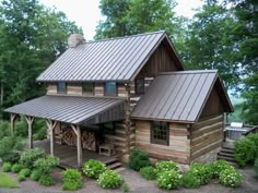 a log cabin sits in the middle of a wooded area with trees and shrubs surrounding it