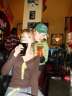 two women sitting at a table drinking beer