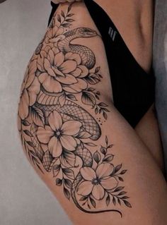 a woman's thigh with flowers and snakes on it