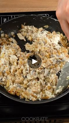 someone is using a knife to cut up food in a skillet on the stove