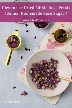 a white bowl filled with purple flowers next to a spoon and some other items on a table