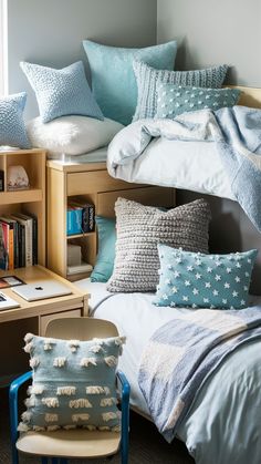 a bed with blue and white pillows on top of it next to a book shelf