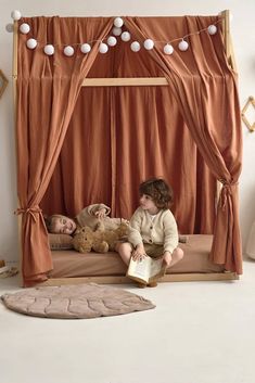 two children are sitting on a bed with a teddy bear and an open book in front of them