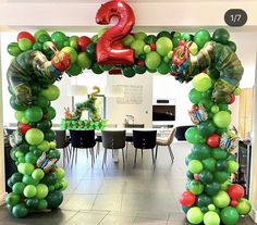 an arch made out of balloons with the number 2 on it in front of a dining room table