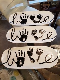 two white plates with black hand prints on them