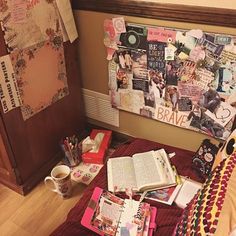 an open book sitting on top of a bed next to a wooden headboard covered in papers