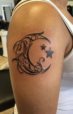 a woman's arm with a crescent and stars tattoo on the back of her shoulder