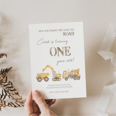 a person holding up a card with construction vehicles on it