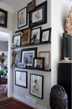 a living room with pictures on the wall and an entertainment center in the corner next to it